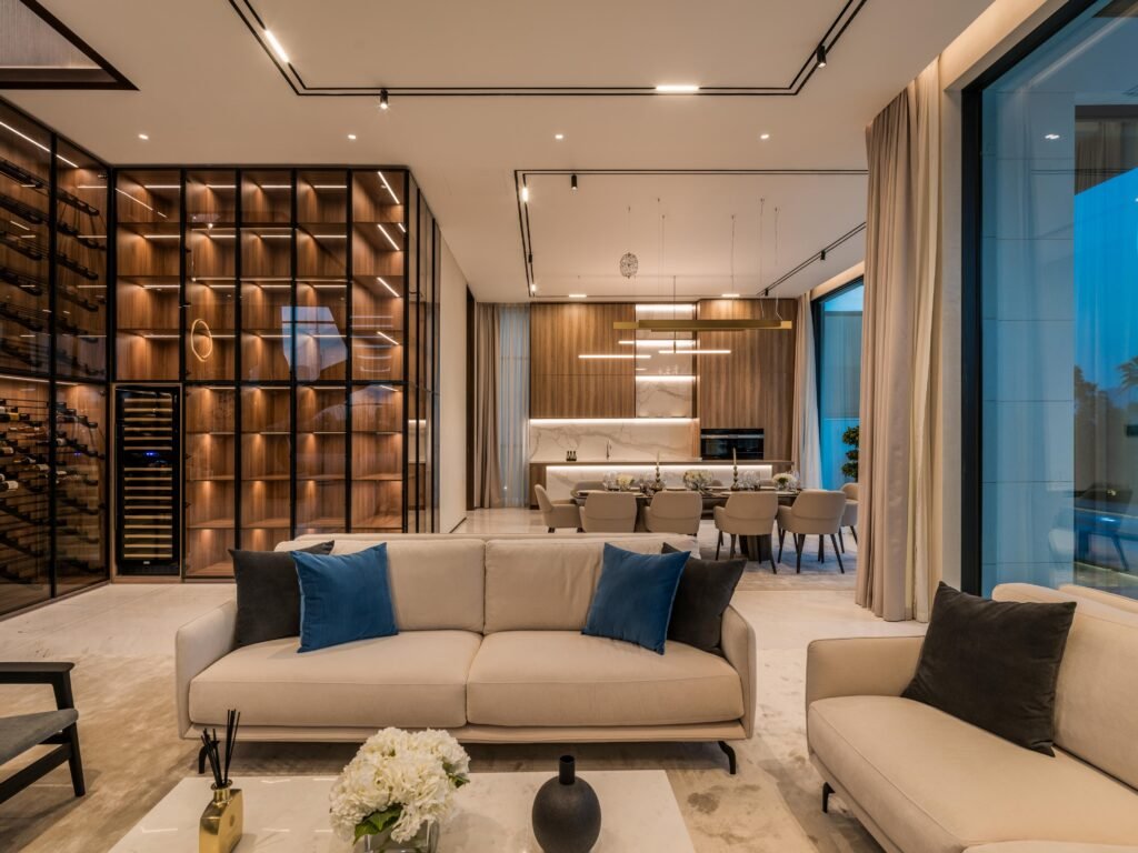 Living room with floor to ceiling wine wall, kitchen and dining beyond, Harrisoni Villas, La Mer South, Jumeirah 1, Dubai